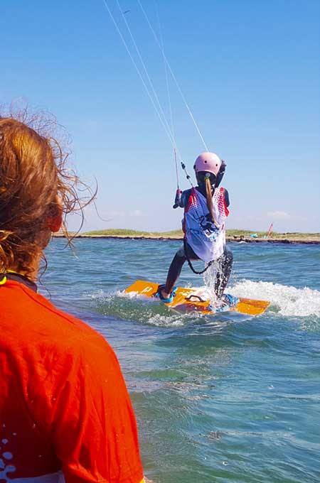 Kiteboard dersinde rüzgaraltı kayan öğrenci .